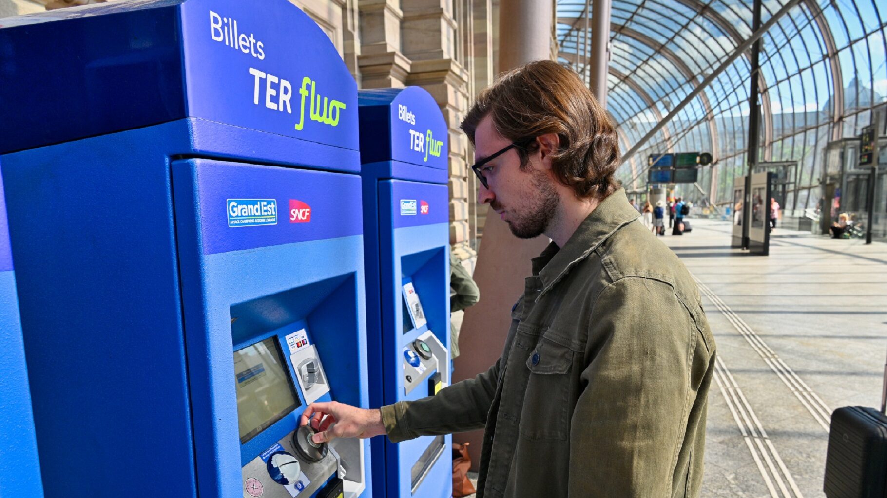 Jeune - Voyageur prenant son billet sur une borne en gare de Stg