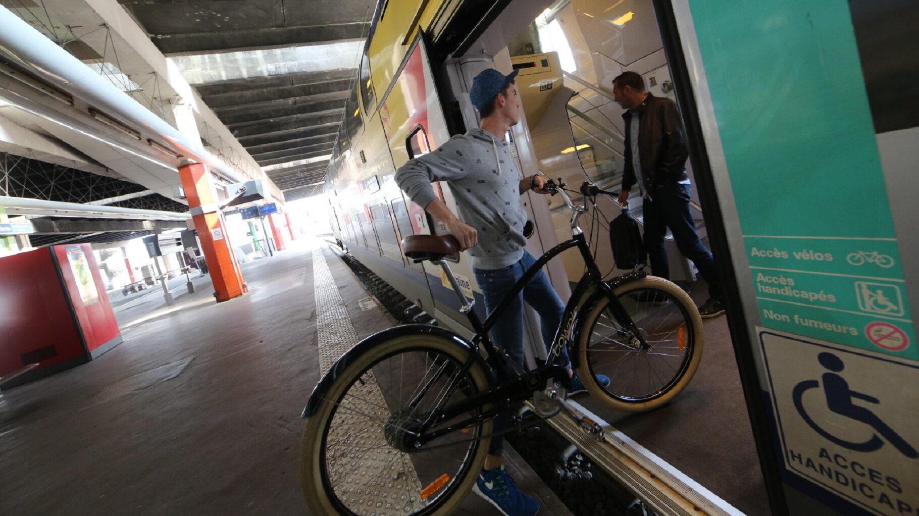 Jeune montant son velo dans le train