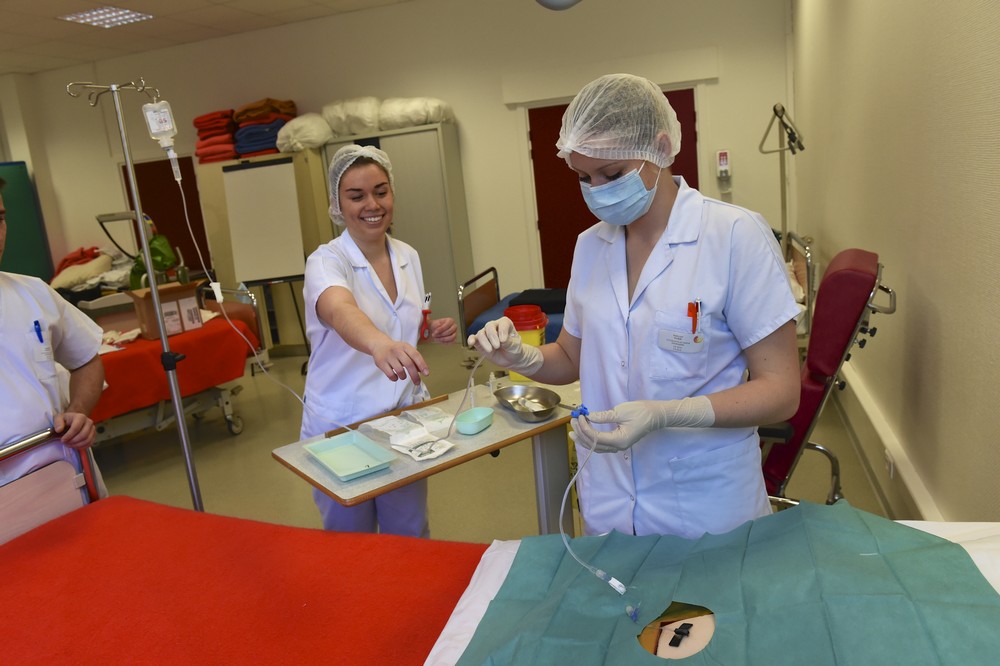Etudiants en soins infirmiers se preparant a une simulation d'operation sur un mannequin   formations sanitaires et sociales